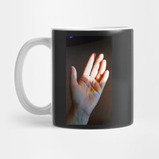 Helping Hand Holding a Rainbow Mug